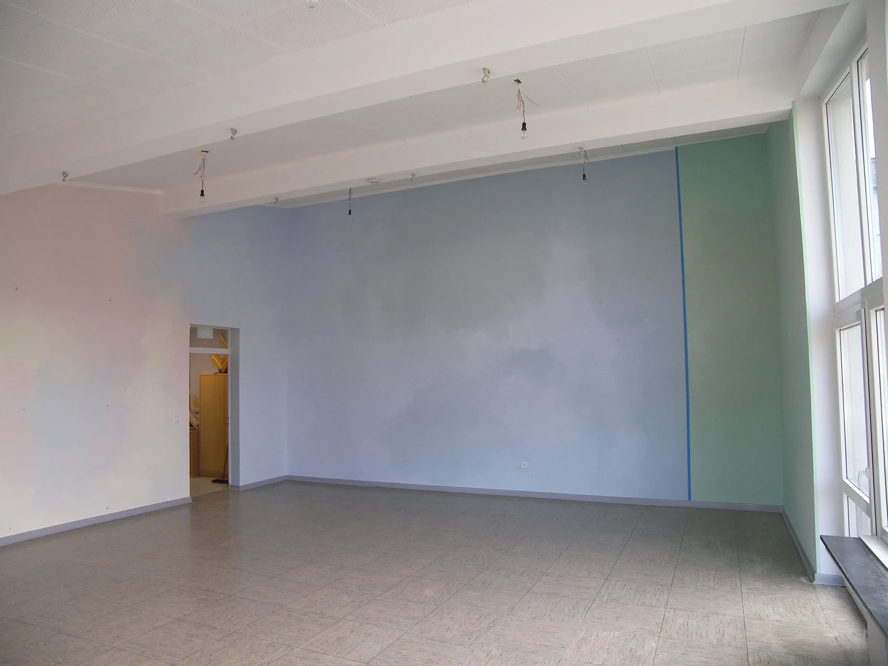 Großer Raum mit blau und mintfarben gestalteten Wänden