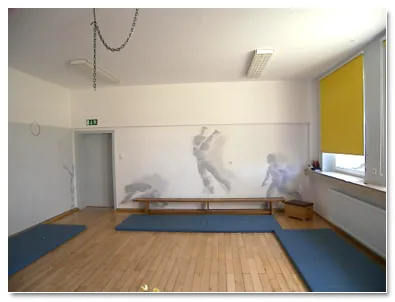 Bewegungsraum mit grauen Figuren an der Wand