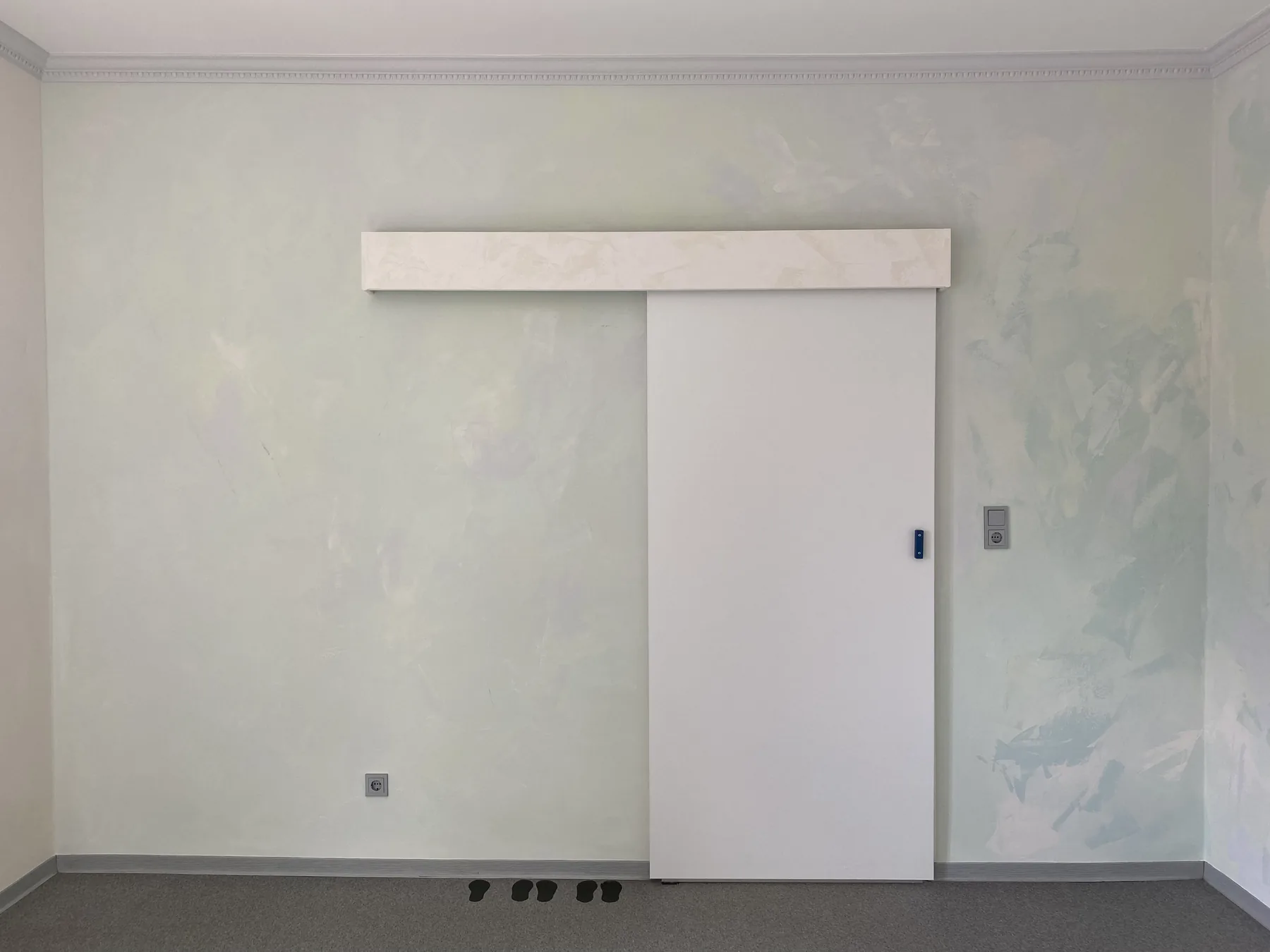 Hell gestaltete Wand mit weißer Schiebetür