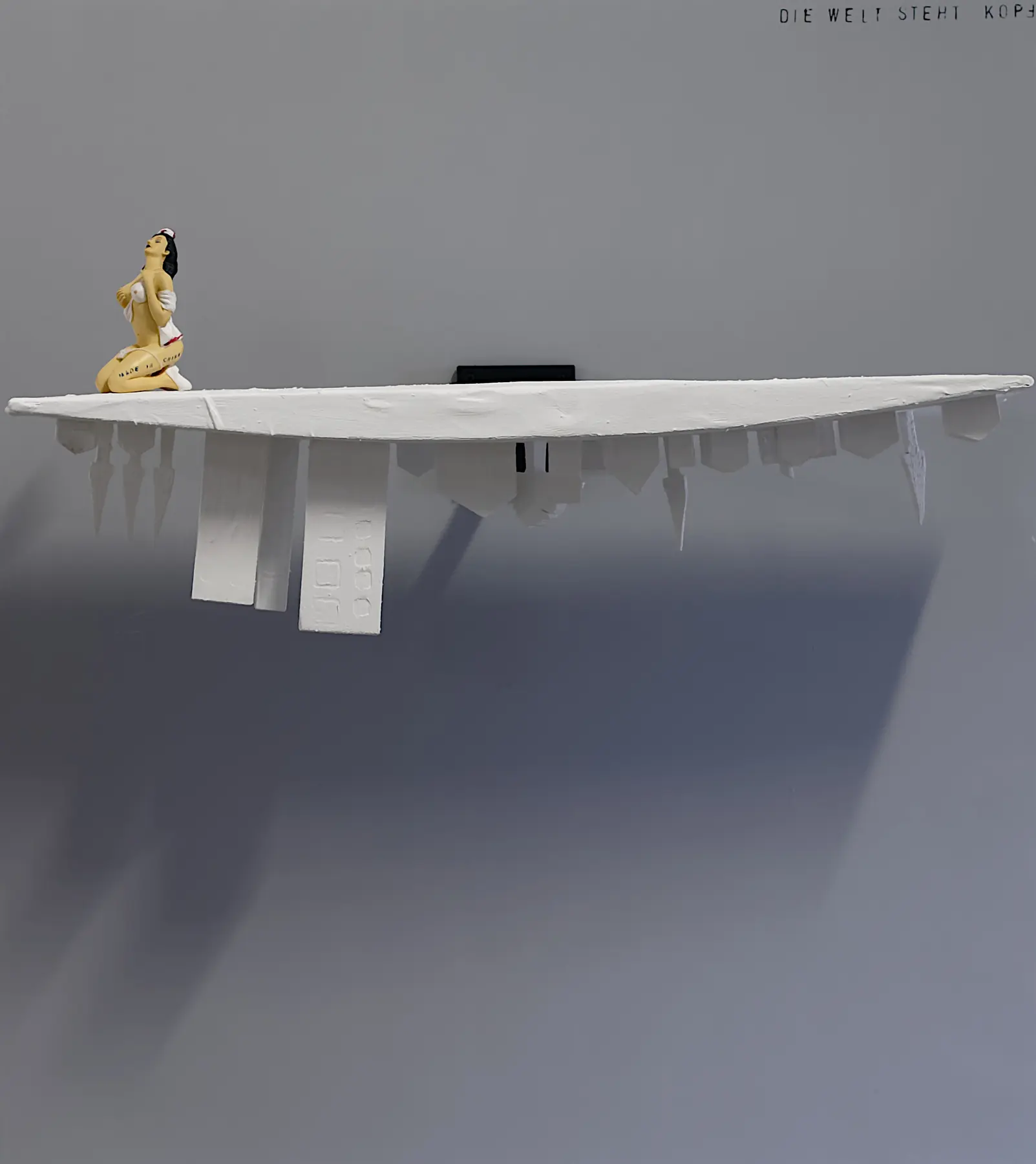 Kleine Skulptur auf einem wandmontierten Objekt