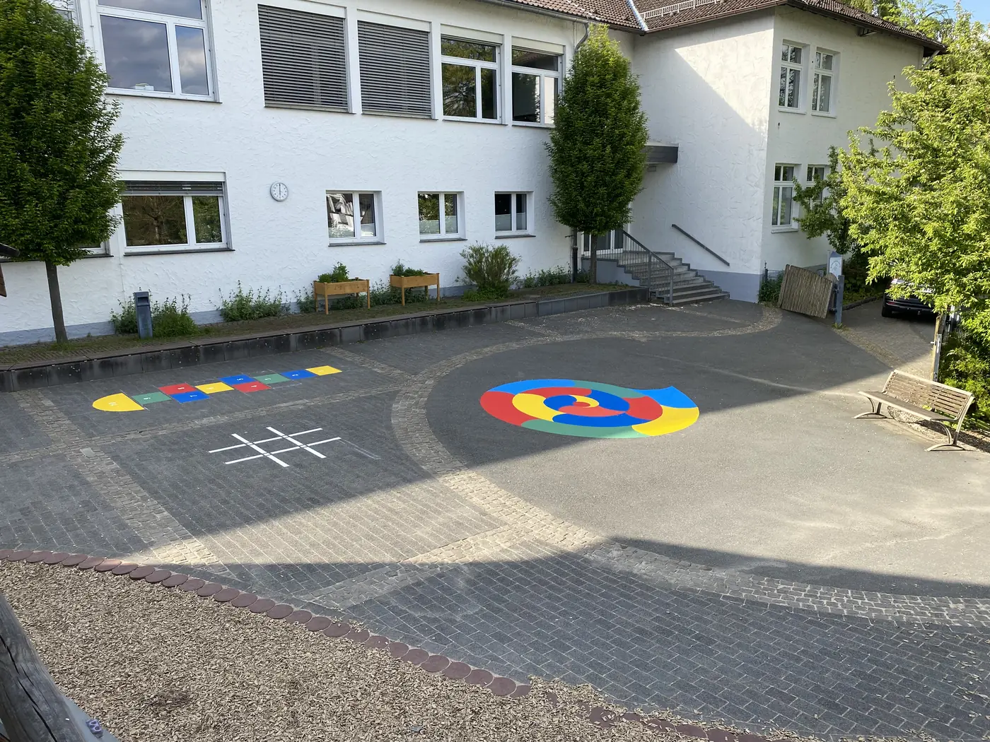 Schulhof mit mehreren farbigen Spielfeldern